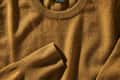 Closeup photo of a brown cashmere sweater. Tag is showing, reading "100% cashmere"