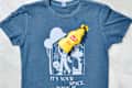 overhead shot of a blue t-shirt with a mustard stain and a bottle of french's mustard