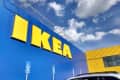 IKEA store exterior with large yellow logo on blue wall, under a partly cloudy sky.