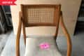 Wooden chair with cane backrest and worn beige seat cushion, marked "Before" with a pink note on the seat.