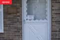 Before: Dingy white front door with scalloped edges against brick siding