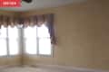 Before: Beige living room with maroon curtains