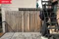 Before: Empty patio with brown wood fence