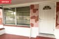 Before: red porch with pink and red camo-patterned house exterior and white door