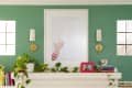 fireplace with green wall and gold sconces hanging above