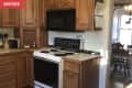 Before: Brown wood kitchen cabinets with dated range