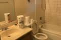 Before: Dingy bathroom with dirty grout and holes in wall
