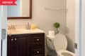 Before: Bathroom with dark wood vanity and white walls