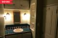 Before: Dark green-painted bathroom with tiled vanity