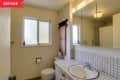 Before: dated bathroom with dingy walls, low lighting, and a tiled countertop