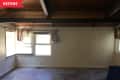 Before: Empty room with open ceilings and off-white shiplap on walls