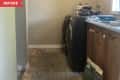 Before: beige laundry room with small closet and wood cabinets