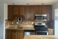 Before: kitchen with brown counters, cabinets, and backsplash