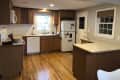 Before: Kitchen with brown cabinetry white appliances