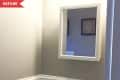 Before: Corner of bathroom with rectangular mirror/medicine cabinet and tan walls