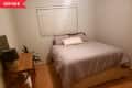 Before: White bedroom with wood floor, featuring only a bed and a table