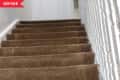 Before: stairs with white balusters and brown carpet
