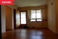 Before: Empty living room with wood floors and beige walls