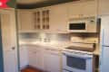 Before: Dated kitchen with white cabinets and white appliances