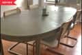 Before: Dining table with gray wood stain, surrounded by caned dining chairs