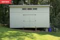 Before: Plain white shed in a yard