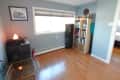 Before: Room with light blue walls and hardwood floors, furnished with a bookshelf and other assorted furniture