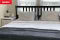 Bedroom with yellowish walls and black basic IKEA bed