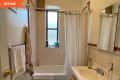 Small bathroom with a shower curtain, window, sink, mirror, and towel rack.