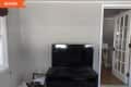 Before: Blank gray wall with a tv on a black TV stand sitting in front of it