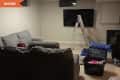 Before: Cluttered basement with beige walls and carpet