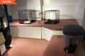 Before: Pink-carpeted basement with platform