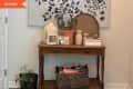 Before: Entryway with beige walls, large artwork, and wooden console table