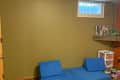 Before: Basement with green wall and broken window