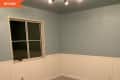 Empty room with blue upper walls, white wainscoting, a window, and beige carpet, labeled "Before."