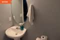 Before: gray bathroom with white sink and oval mirror