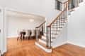 A plain staircase with white risers, wood-toned treads, and iron spindles.