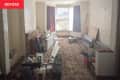 Living room before renovation/makeover. Old, dark patterned carpet, off white textured walls