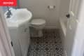 Before: Bathroom with black and tan floor tile