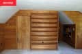 Bookshelves in bedroom with wood panel walls before renovation.