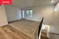 And empty room at the top of the stairs with white walls and beige carpet
