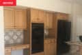 Before: Dated kitchen with tan cabinetry and beige walls