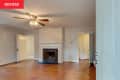 A white-painted room with a black tile fireplace and wood floors.