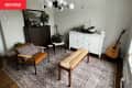 A living room with two chairs, a bench, and a cabinet.