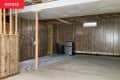 Empty wood-paneled cement-floored basement before renovation