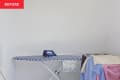 A laundry room with racks and ironing board.