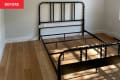 Black bed frame in bedroom before renovation.