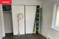 Ladder leaning against closet doors in living room being renovated.