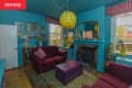 Living room with teal walls, pink decor, and a yellow light fixture