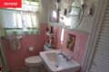 white bathroom with pink tile and gray floor before remodel