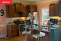 Kitchen with brown cabinets, stainless steel appliances, pink walls, and a cluttered countertop with various items.